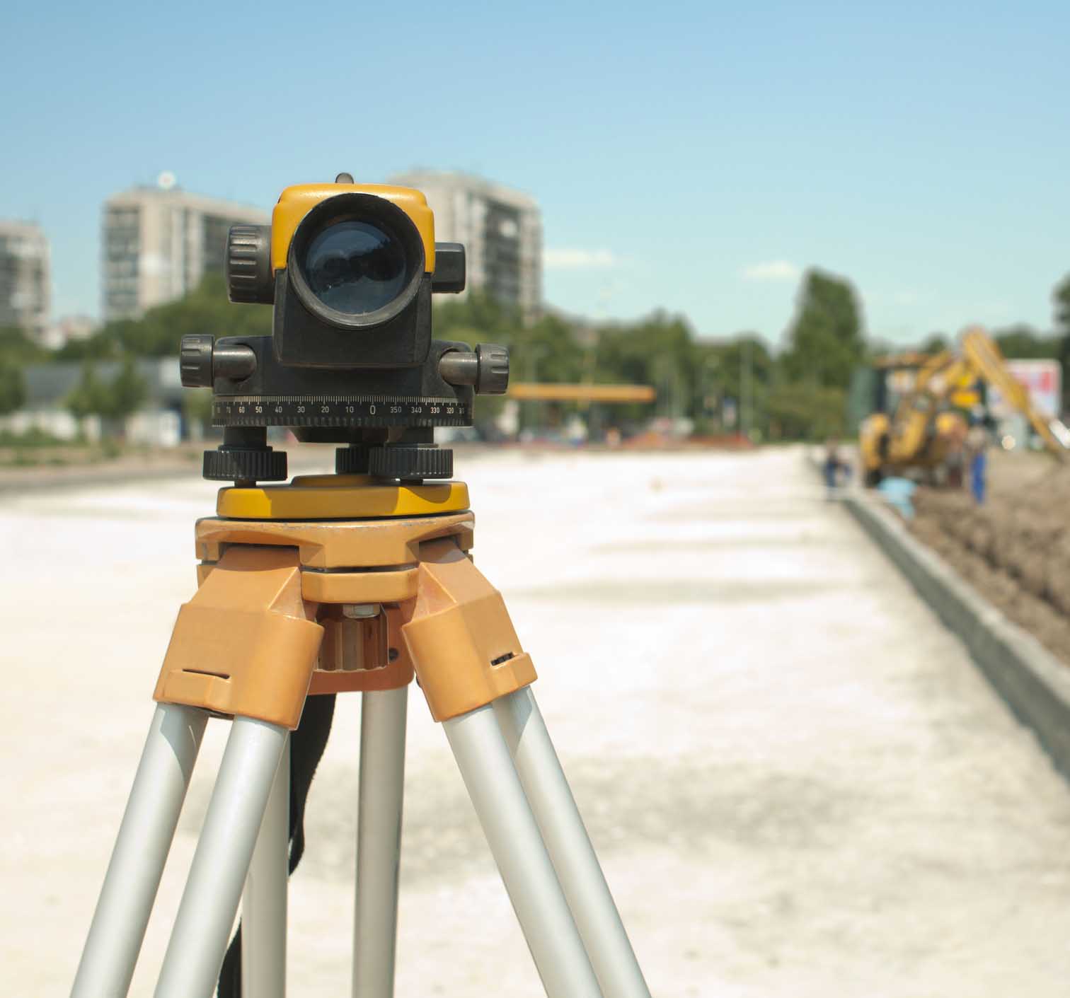 Surveying equipment to infrastructure construction project. Excavator on the background